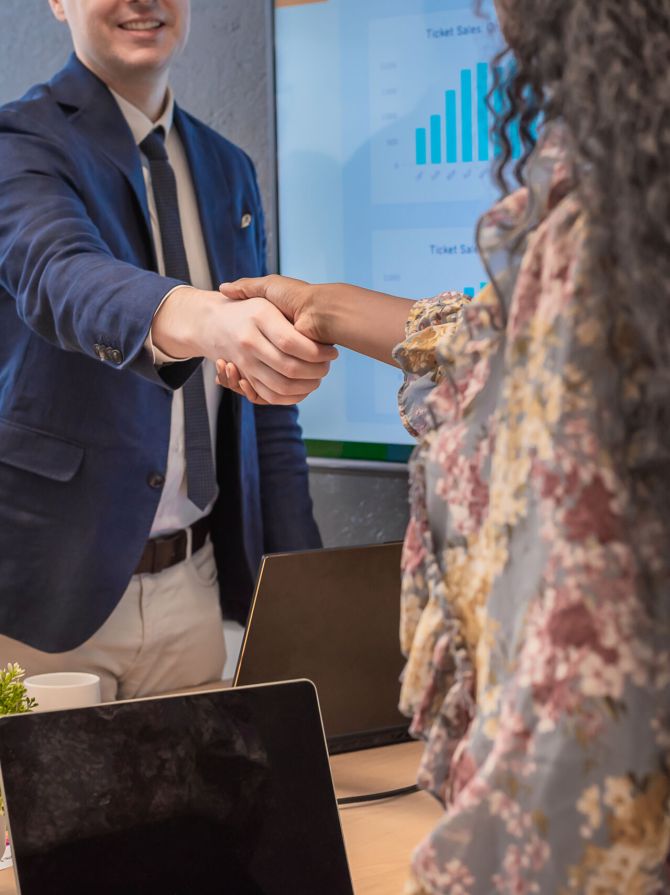 Business man shake hands with business women agreeing on partnerships or introducing themselves for first time meet.