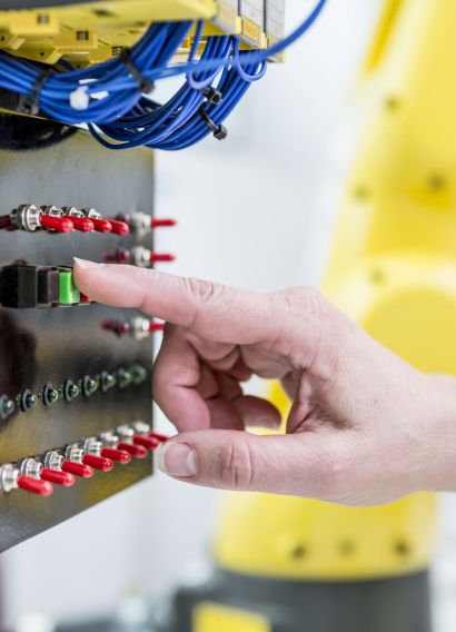 Close-up of woman switching on switch in factory